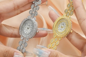 Close-up of gold and silver women's quartz watches with sparkling rhinestone leaf bracelets