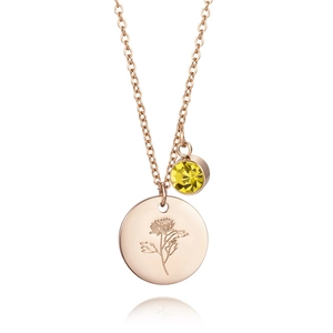 Detail of rose gold birthday necklace featuring a flower tag and yellow gemstone pendant