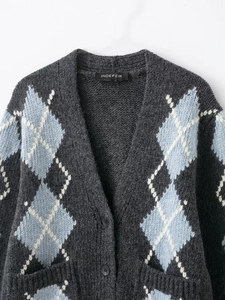 Detail of argyle knit cardigan featuring V-neckline and textured grey blue diamond pattern