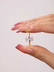 Close-up of gold-plated ring featuring a clear oval-cut zircon in a six-prong setting