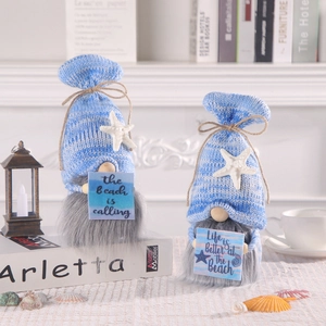 Nautical gnome figurines with blue striped hats and beach themed signs on shells