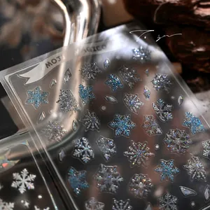 Macro shot of glittery snowflake nail stickers with holographic blue and silver laser effects