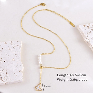 Detail view of 18K gold butterfly necklace with white pearls and shell pendant texture