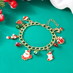 Detailed shot of Christmas charm bracelet with Santa, bells and socks on green background