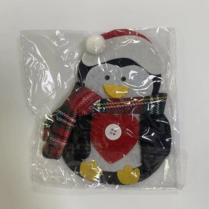 Close-up of a Christmas penguin cutlery holder with red heart and festive scarf details