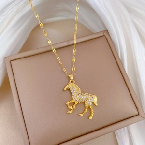 Luxurious gold horse pendant necklace with sparkling crystals on a cream jewelry box