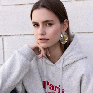Macro shot of large two-tone gold and silver circular earrings on a model in vintage style