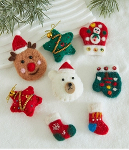 Close-up of handmade wool felt Christmas ornaments including reindeer and white bear shapes