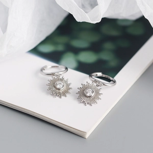 Detail of s925 silver bohemian earrings with sunburst charms and clear crystals