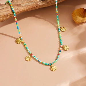 Detailed shot of bohemian colorful bead necklace with five golden embossed sun pendants