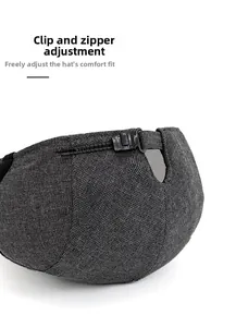 Detailed view of the adjustable zipper buckle on the back of this dark grey flat cap