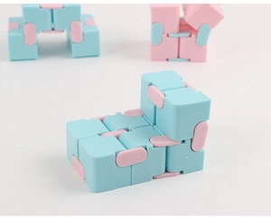 Macro detail of pink and blue infinity fidget cubes on a clean white surface