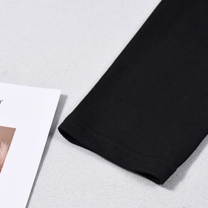 Close-up of black knitted fabric showing fine double stitching and elastic texture