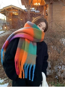 Detail of colorful rainbow plaid scarf with thick tassels and soft cashmere-like texture