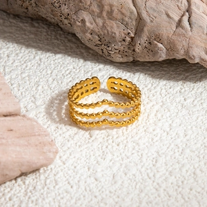 Detail view of 18K gold plated multi-layer heart shaped open ring on natural stone