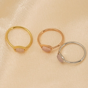 Détail de trois bagues en acier inoxydable or argent or rose avec pierres de quartz rose