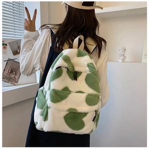 Detail of plush backpack featuring green and white heart patterns with fuzzy texture