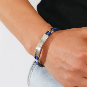 Gros plan du bracelet en acier inoxydable et silicone avec rayures bleues au poignet