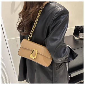 Detail of a khaki leather shoulder bag with a gold chain strap and metallic buckle