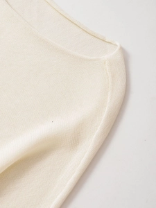 Close-up of finely knitted neckline and shoulder seams of an ivory knit sweater