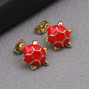 Macro shot of red enamel turtle stud earrings with elegant gold-plated metallic edges
