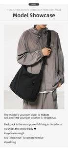 Minimalist large black nylon crossbody bag shown on model with adjustable strap