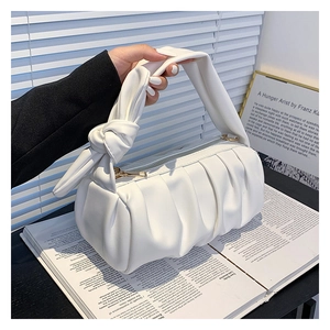 Detail of white pleated cloud bag with knotted handle design and soft leather texture