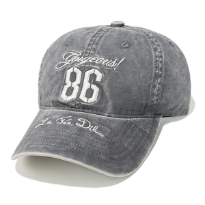 Detail of grey washed cotton baseball cap with white Gorgeous 86 patch embroidery