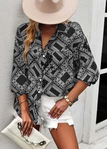 Fashionable black paisley print shirt with three-quarter sleeves on model against white wall