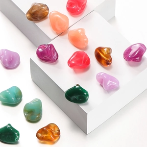 Close-up of irregular colorful acrylic stone beads with marble texture for DIY jewelry