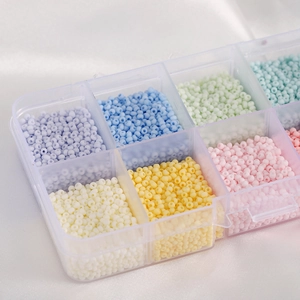 Macro view of colorful macaron glass seed beads organized in a clear multi-grid storage box
