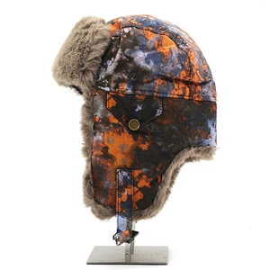 Detail of winter trapper hat with colorful camo pattern, thick faux fur and side pocket