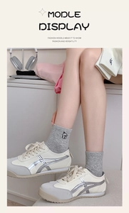 Detailed close-up of crew socks featuring an embroidered puppy motif and silver sneakers