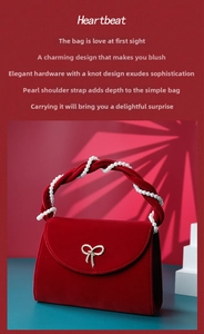 Detail of red velvet handbag with pearl handle and golden ribbon hardware