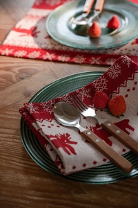 Detailed Christmas table setting with jacquard napkins featuring reindeer and snowflake patterns