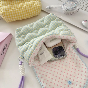 Detail of quilted heart pattern crossbody bag showing internal storage for phone and accessories