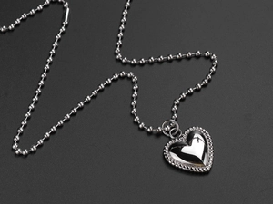 Detailed close-up of polished titanium steel double heart pendant on a bead chain necklace