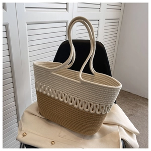 Detail of two-tone beige woven cotton tote bag with wavy patterns on a textured jacket