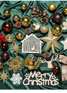 Flat lay of gold and red Christmas tree ornaments on dark green silk background