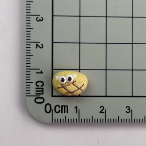 Mini resin yellow cartoon bread charm with big eyes on a measuring scale for DIY craft