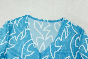 Détail du col en V avec maille bleue et blanche et coutures de précision sur la robe