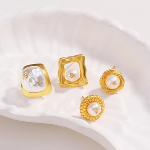 Détail de boucles d'oreilles fleur de lave plaquées or 18k avec perles sur coquillage