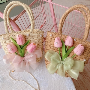 Detail of straw handbags with tulip fabric flowers, pearls, and large silk bows on lace
