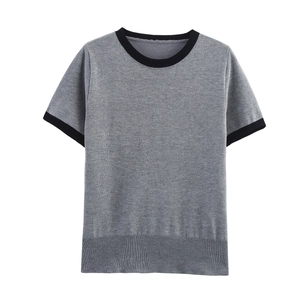 Détail d'un haut en tricot gris avec col rond noir et bordures côtelées contrastées