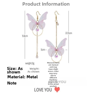 Détail de boucles d'oreilles papillon asymétriques avec perles et longues chaînes