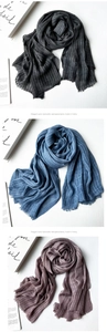 Detailed view of striped modal scarves in grey, blue, and pink with fringed edges