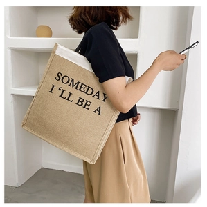 Detail of jute texture tote bag with black letter print and contrast stitching