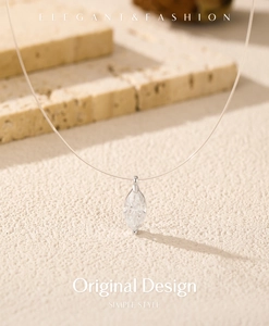 Detail of marquise-cut moissanite pendant on a clear fishline chain jewelry
