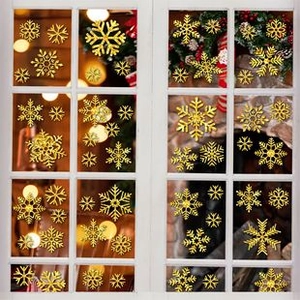 Nahaufnahme goldener Schneeflocken-Fensteraufkleber auf Glas mit festlicher Deko