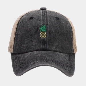 Macro shot of embroidered pineapple detail on washed cotton mesh baseball cap